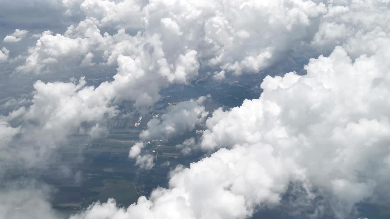 Stunning footage of aerial view above clouds from airplane window with blue sky. view from the airplane window to the blue sky and white clouds. view of the earth from the sky through the clouds