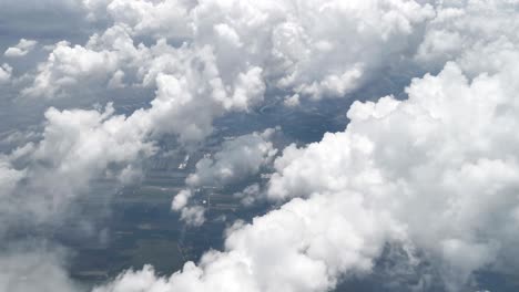 stunning footage of aerial view above clouds from airplane window with blue sky. view from the airplane window to the blue sky and white clouds. view of the earth from the sky through the clouds