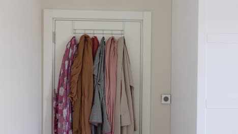 scarves and clothes hanging on a white door