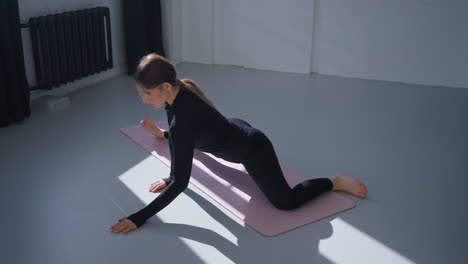 woman doing a yoga stretch on a mat