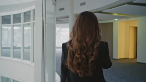 office professional talking smartphone go hall back view. stylish businesswoman