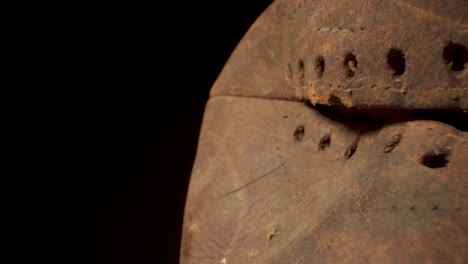 Tracking-shot-past-a-old-leather-rugby-ball-with-a-black-background