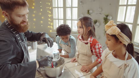 chef showing kids how to use stand mixer on cooking masterclass