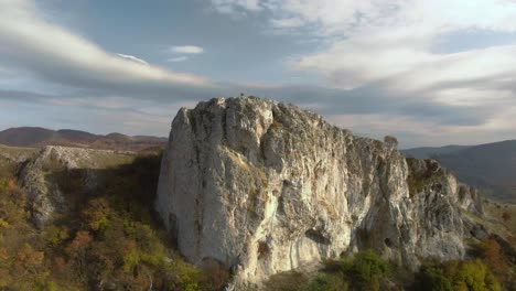 Toma-Panorámica-Aérea-De-Gran-Roca-Alta-En-El-Borde-De-Una-Montaña