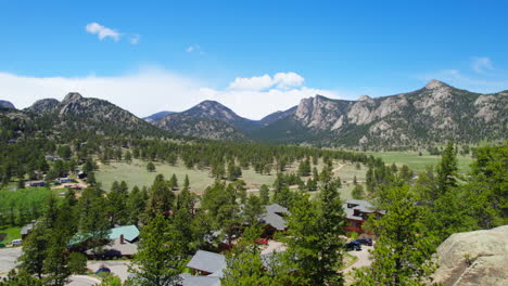 HD-Aerial-Drone-Shot-Flying-Past-Rural-House-Buildings-Revealing-Beautiful-Scenic-Country-Landscape-With-Pine-trees,-Large-Boulders,-And-Epic-Rocky-Mountain-Foothills-In-The-Background