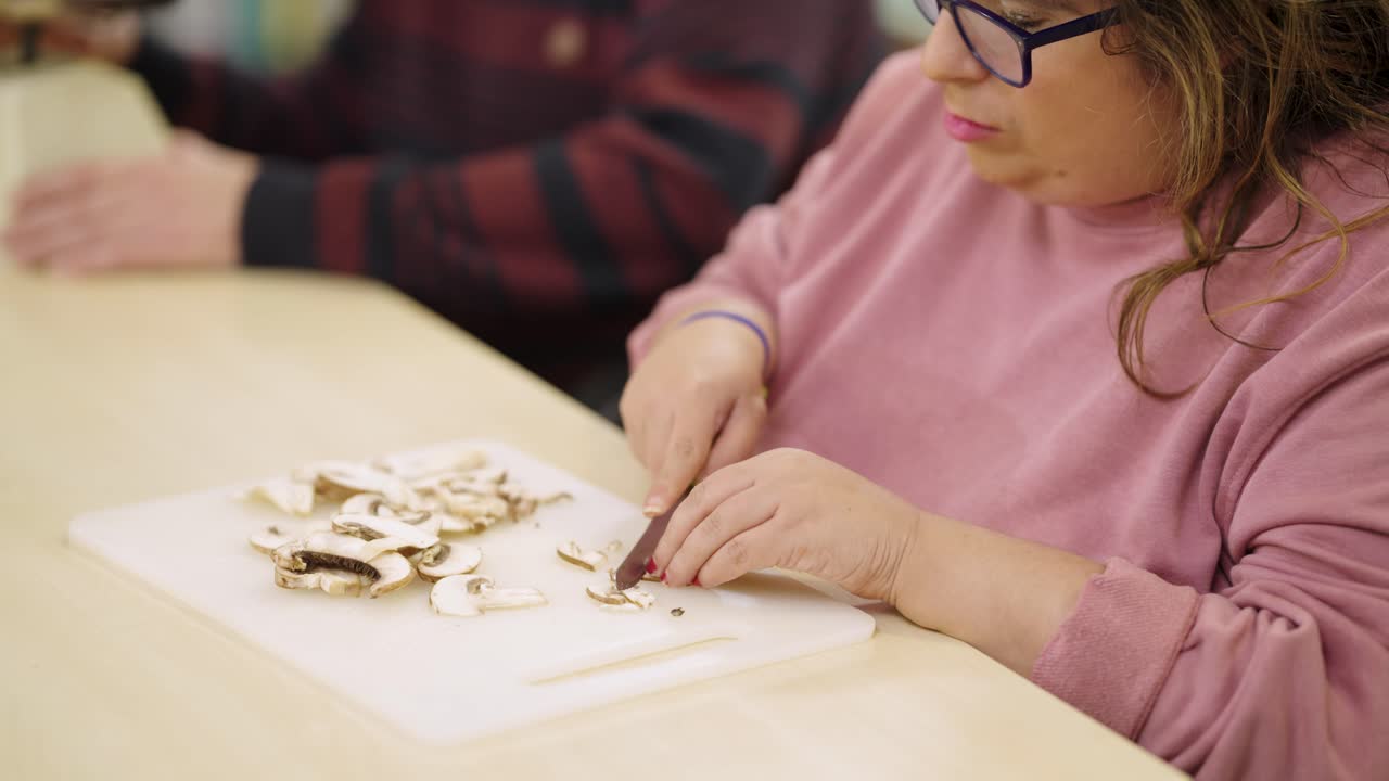 Woman cutting mushrooms in the kitchen