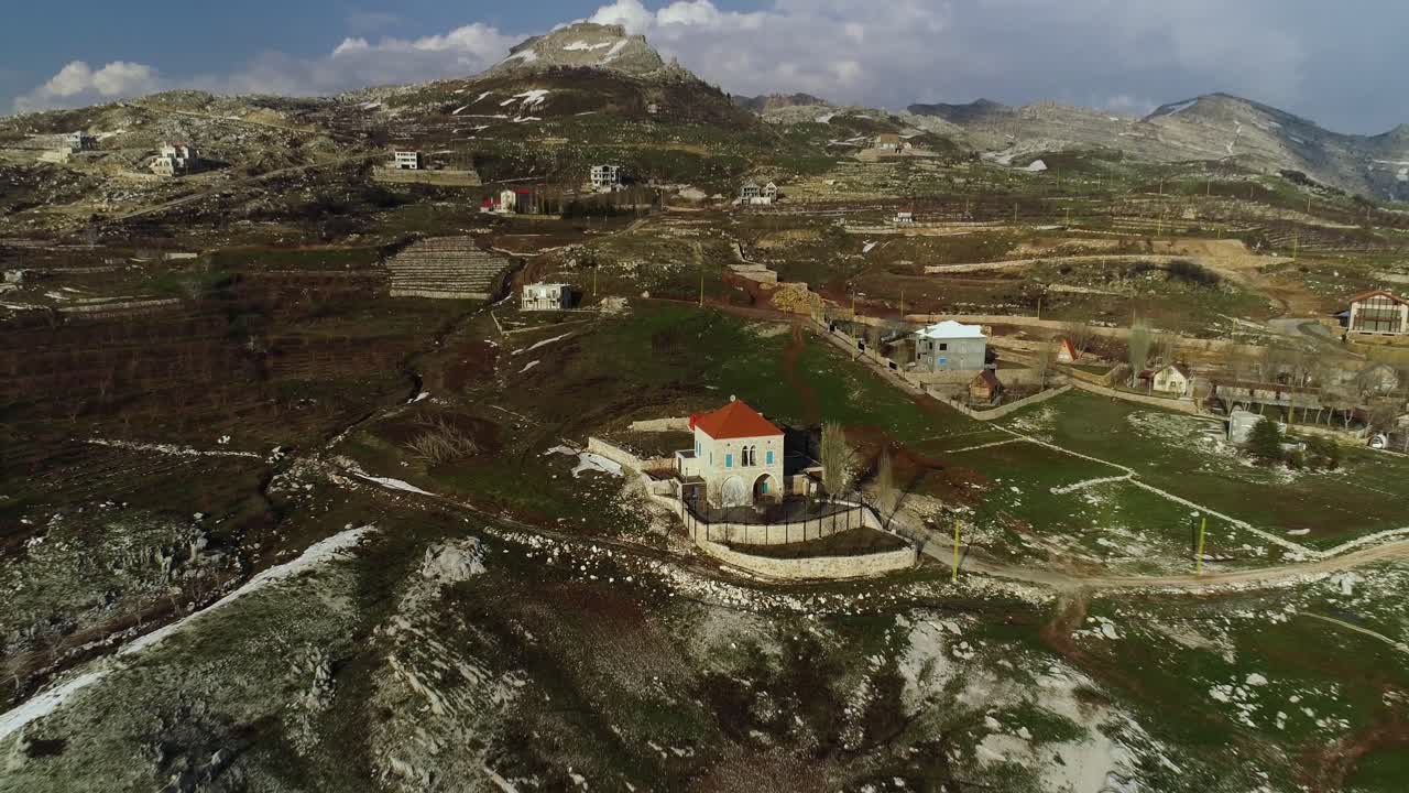 Aerial pull back view of Akoura House and majestic mountain range, Lebanon