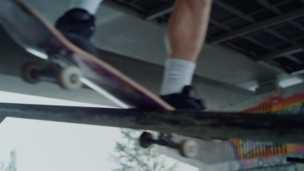 adolescente activo practicando el truco de salto en el carril en la tabla de patinaje en el parque de patinaje.