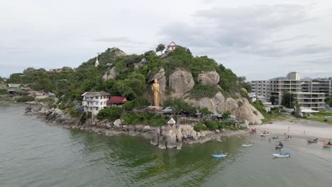 Famous-Golden-Buddha-Statue-on-Rock-Shore-in-Hua-Hin,-Takiap-Beach