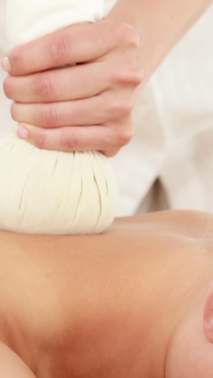 Woman enjoying a herbal compress massage