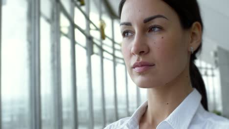 una mujer de negocios confiada mirando por la ventana.