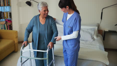 nurse helping senior woman walk with a walker