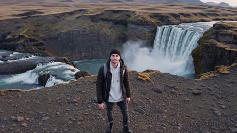 Man waving at a Waterfall in Iceland