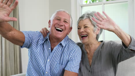 una pareja feliz se despide con sus manos.