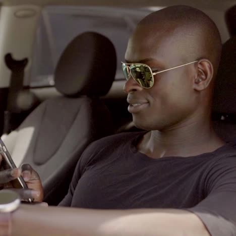 man driving a car and checking his mobile