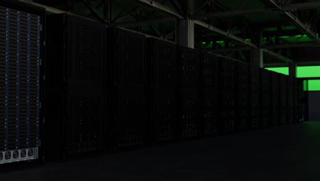 Server-farm-in-warehouse-with-flashing-green-light,-pullback-shot