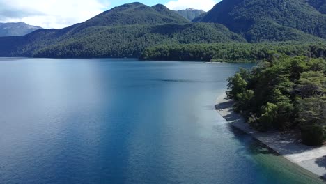 asombrosa foto de un gran lago azul con montañas cubiertas de árboles en el lago futalaufquen patagonia, argentina