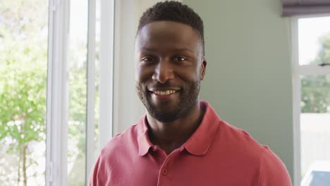 retrato de un feliz hombre afroamericano sonriendo en la sala de estar