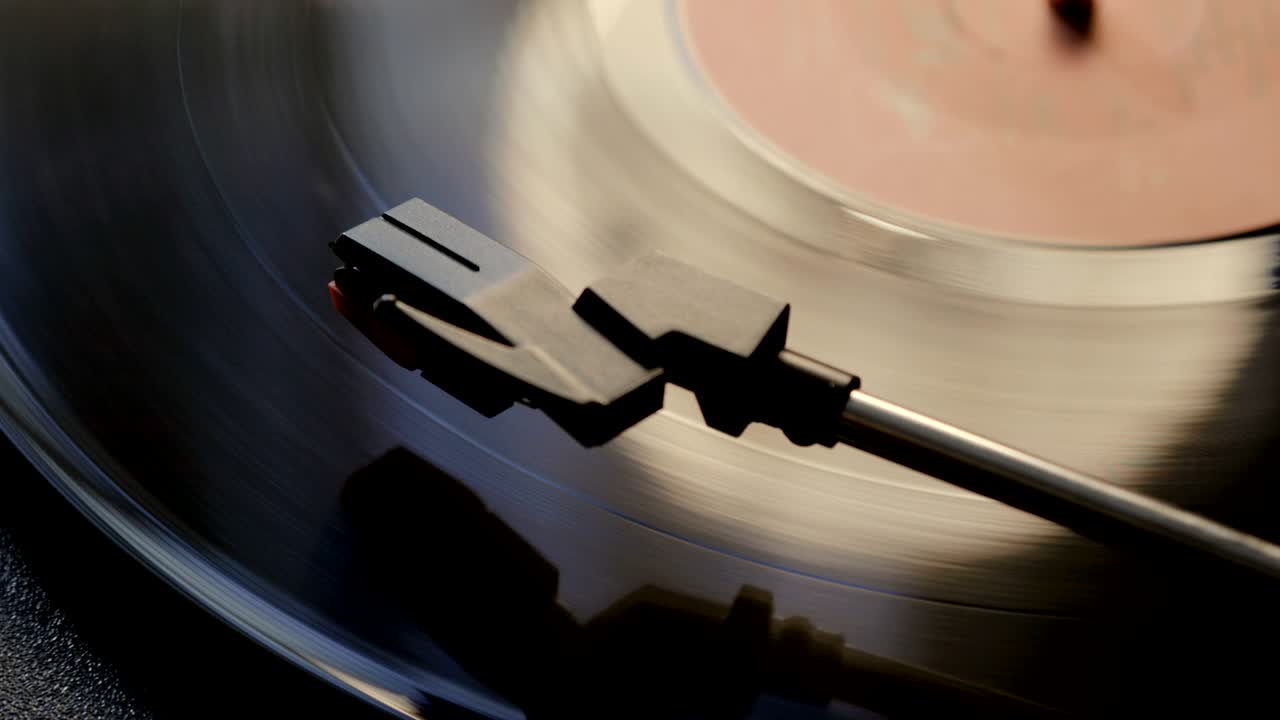 고대 비닐 레코드 플레이어를 사용하는 클로즈업. 턴테이블 플레이어, 비닐 레코드를 재생하는 스타일러스 바늘을 떨어뜨리는