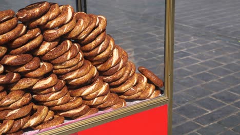 a pile of turkish simit bread rolls on a street vendor cart