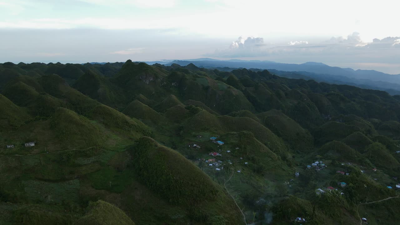 pico de osmena al anochecer con colinas verdes y comunidad rural dispersa, vista aérea