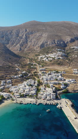 panoramic drone shot of aegiali village and port in amorgos island, greece. vertical