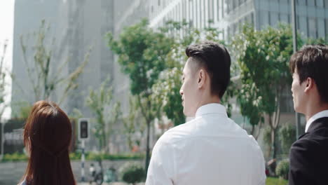 male and female company workers walking together with their handsome boss and giving him their ideas about new project