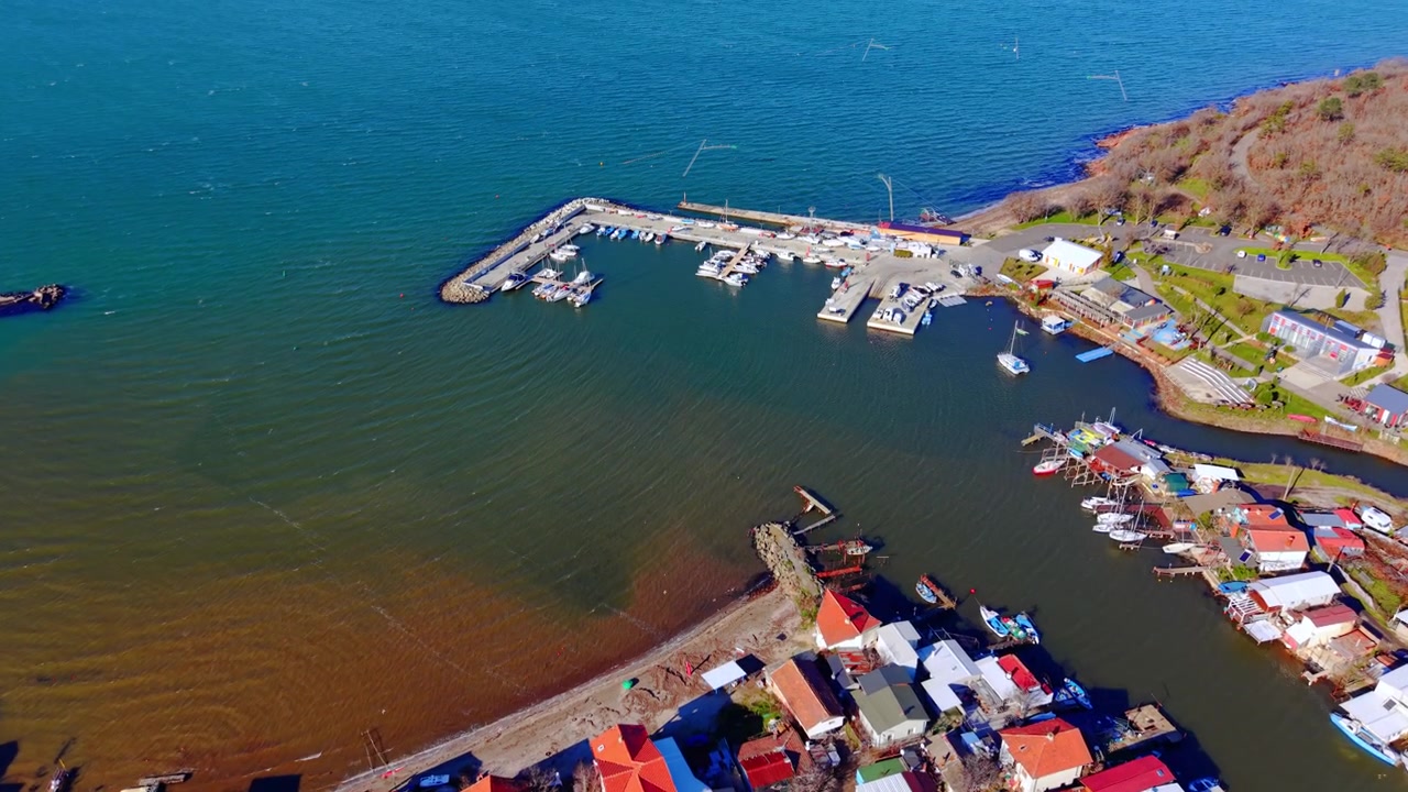Molo marittimo con imbarcazioni accanto a una comunità residenziale sul mare. Vista dall'alto di un piccolo porto e dei moli, Burgas, Bulgaria