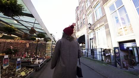 Junge-Glückliche-Frau,-Die-Am-Tulpenblumenmarkt-In-Amsterdam-In-Den-Niederlanden-Vorbeigeht