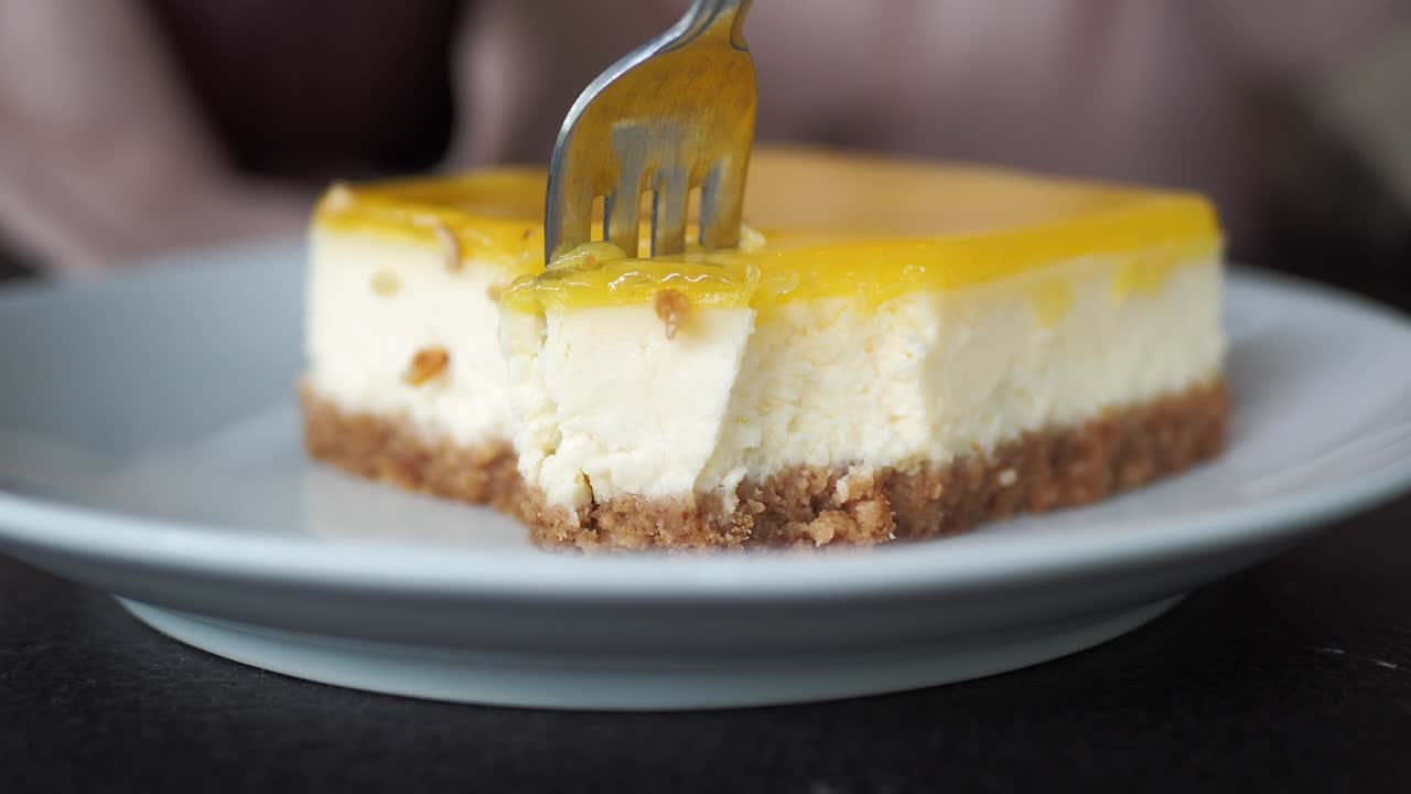 un pedazo de pastel de queso de limón se come con un tenedor