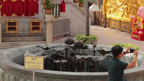 a man captures the fountain with his phone