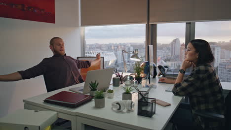 Stretching-creator-feeling-tired-at-office-closeup.-Coworkers-having-deadline