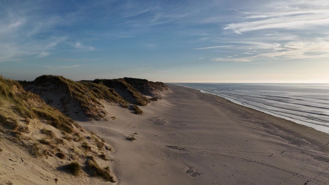 Aftenluftfoto viser strandvandrere og klittoppe