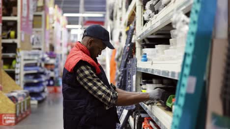 Male-supervisor-arrange-goods-on-shelves-of-hardware-store,-side-view