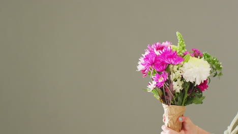 video de una mujer sosteniendo un ramo de flores con espacio de copia en un fondo gris