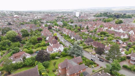 Aerial-view-of-an-upscale-city-street-lined-with-detached-houses,-showcasing-elegance-and-green-surroundings-in-Exeter,-UK