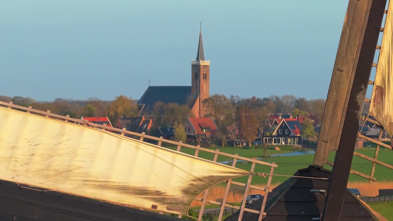 Pale tradizionali di mulini a vento olandesi che girano al tramonto