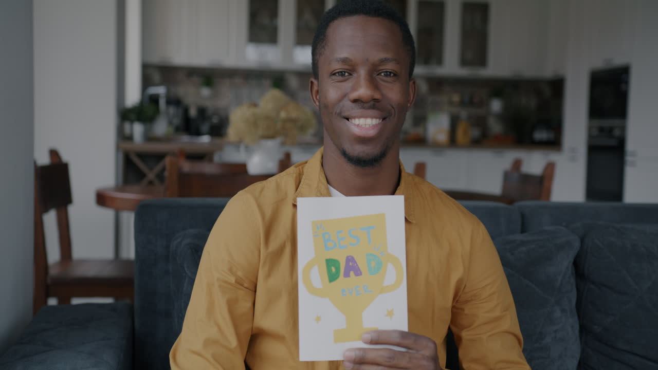 Man Holding a 'Best Dad' Card