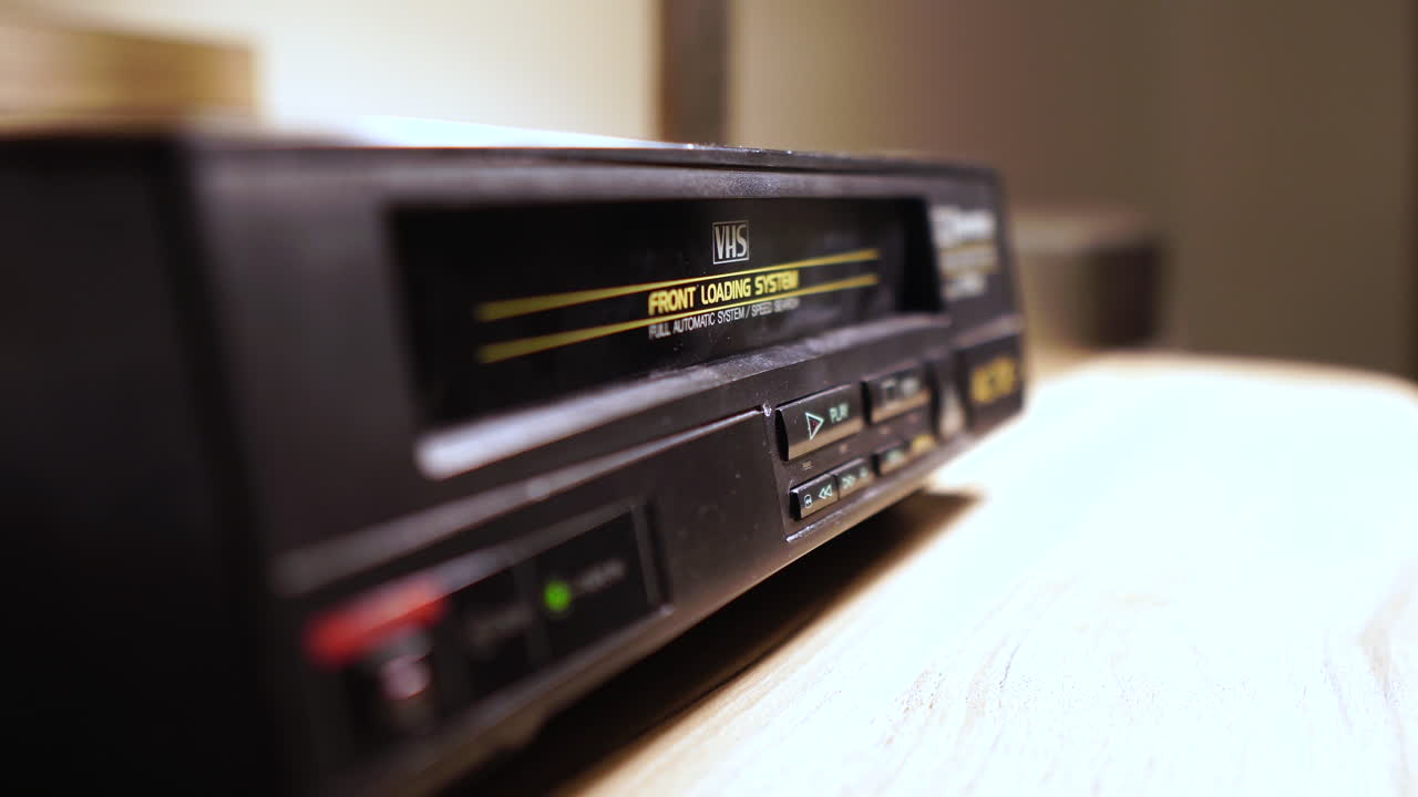 Riproduzione di videocassetta VHS, inserimento e pressione del pulsante Play, primo piano