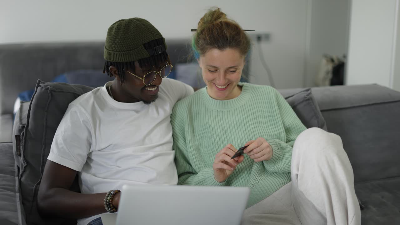A multiracial couple shopping online, orders a food, makes purchases remotely