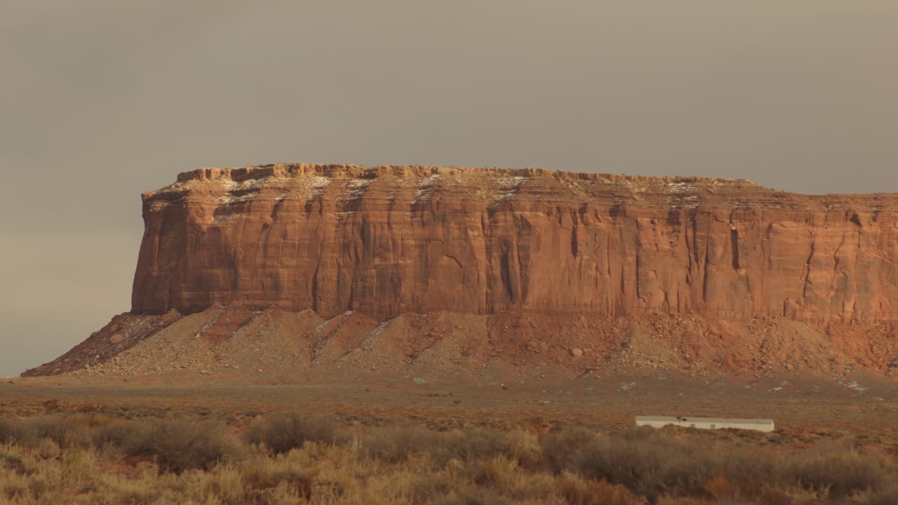 A timelapse of light changing and clouds passing against a huge rock formation in the Southwest desert