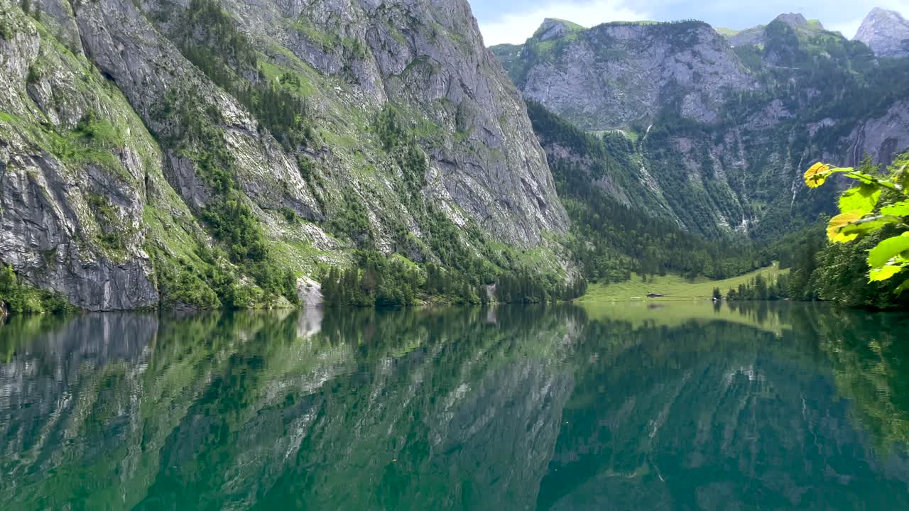 Riflesso sull'acqua di un lago idilliaco circondato da montagne imponenti in estate, Austria - Ripresa in 4K con tilt verso il basso