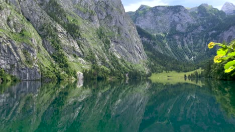water reflection of idyllic lake surrounded by giant mountains in summer,austria - 4k tilt down shot