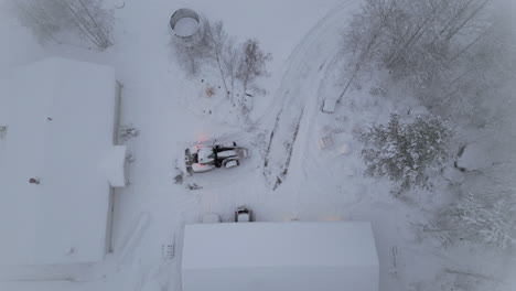 el arado de nieve limpia la nieve en el patio trasero, vista aérea de arriba hacia abajo