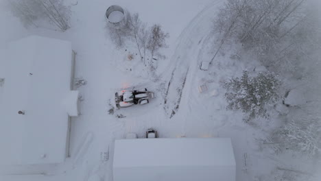 snow plough clears snow in backyard, top down aerial view