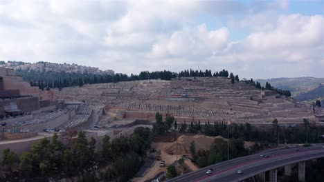 aerial view of a vast cemetery on a hillside overlooking a highway