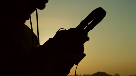 handheld view of man with headphones and mobile phone