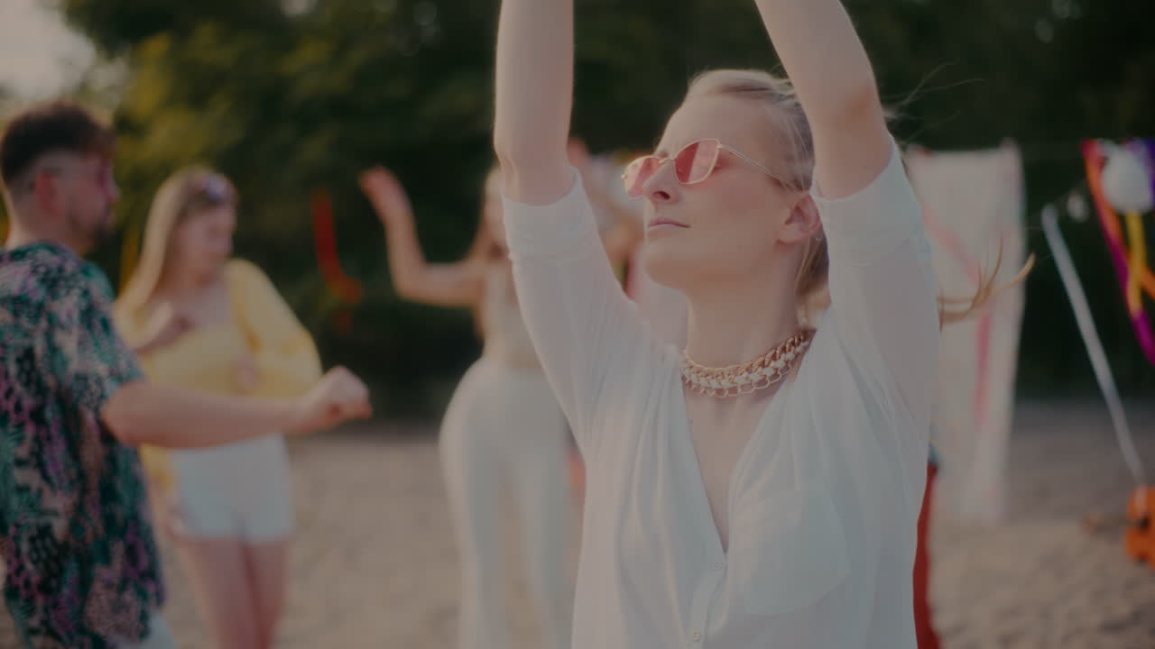 젊은 무관심한 금발 여성이 친구들을 상대로 춤을 춘다