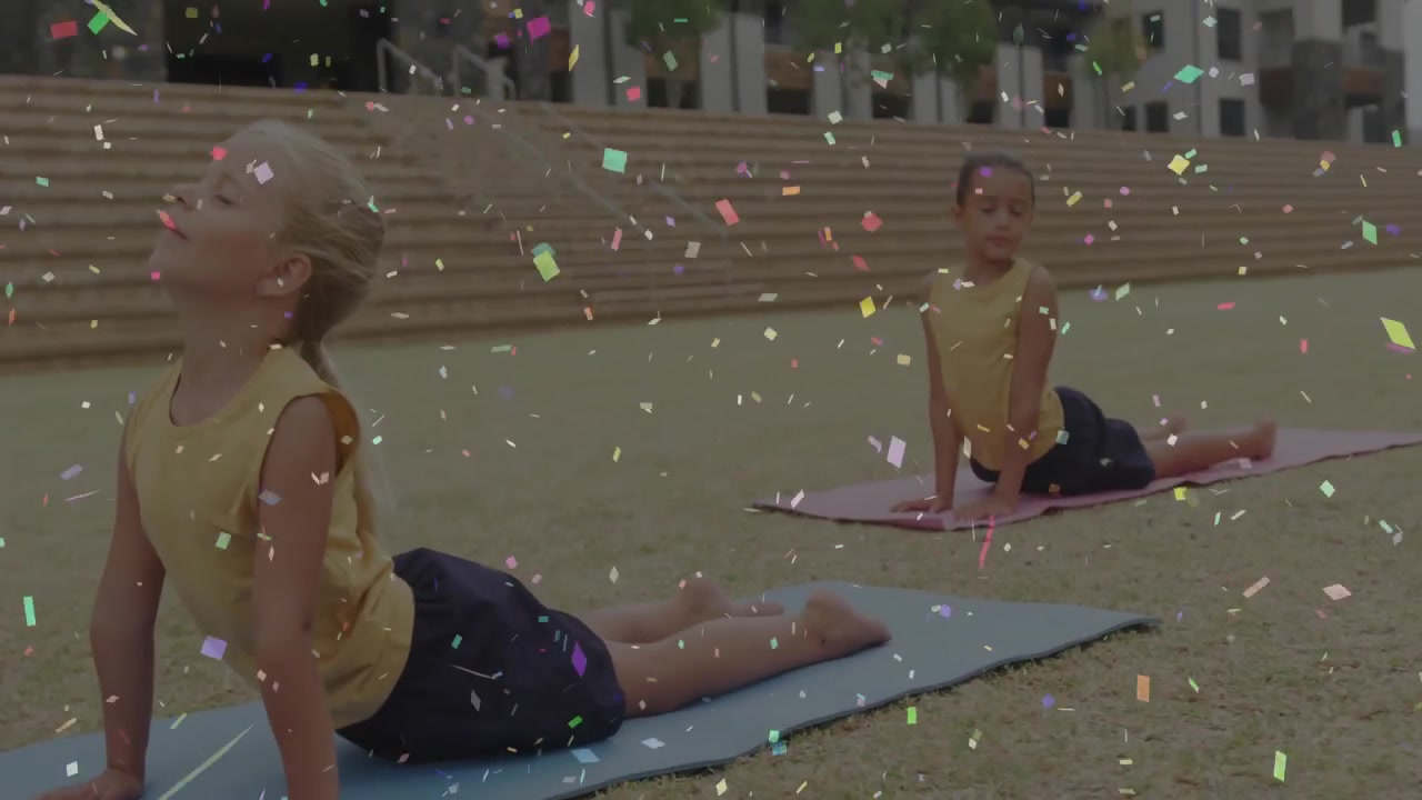Zwei Freunde drücken die Hände auf Yogamatten auf einem grasbewachsenen Platz und führen die Kobra-Dehnung für die Fitness aus.
