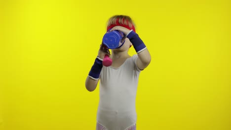 niña con ropa deportiva haciendo ejercicios de fitness con pesas y agua potable. niño atlético